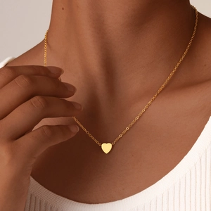 Minimalist gold heart pendant necklace for women shown on a model neck profile