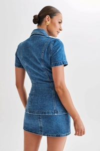 Vue détaillée du dos d'un ensemble en denim bleu délavé avec haut à manches courtes et jupe courte