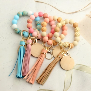 Silicone bead keychain bracelets with checkered patterns, wooden tags, and leather tassels
