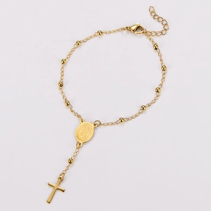 Macro detail of 18k gold plated stainless steel rosary bracelet with cross and medal