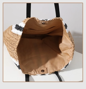 Detail view of large straw tote with magnetic clasp, inner pocket and textile lining
