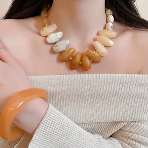 Irregular acrylic resin necklace and bracelet set in amber and cream gradient tones