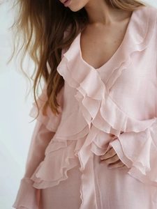 Detail of pink tiered ruffles on a V-neck chiffon dress with soft textured fabric