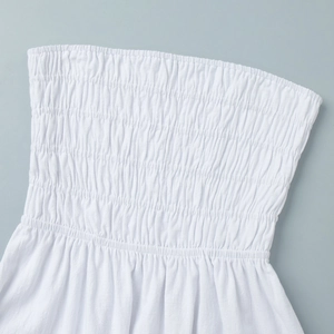 Detail of white cotton smocked bodice showing elastic pleats on a strapless maxi dress