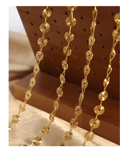 Macro shot of gold-plated titanium necklace with unique spiral geometric link design