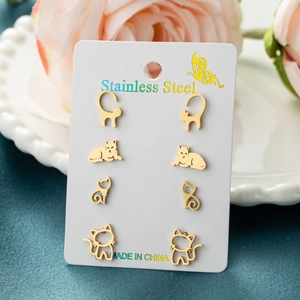 Set of four pairs of golden stainless steel minimalist cartoon cat stud earrings on a card