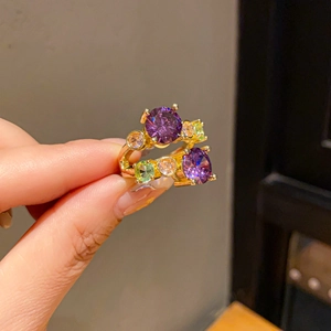 Close-up of vintage flower rings with purple zircon and colorful gems in 18K gold