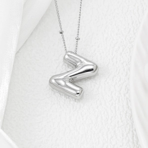 Macro shot of silver balloon style letter Z pendant with glossy mirror finish necklace