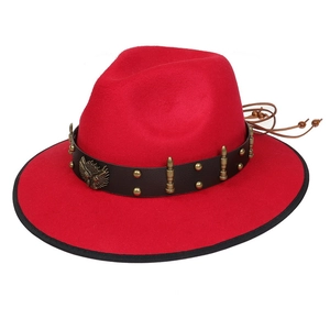 Detail of red cowboy felt hat with leather band, eagle badge and metal bullhead studs