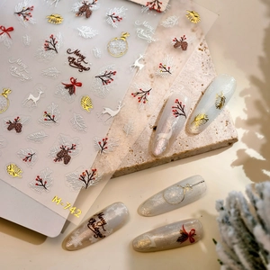 Christmas nail stickers with elk and golden snowflake designs on elegant stone background