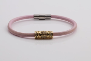 Detail of pink leather cord bracelet with gold crystal charm and silver magnetic clasp