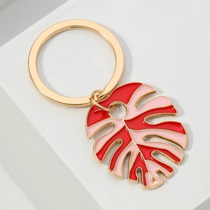 Gold-plated Monstera leaf keychain with vibrant red and pink enamel drip oil design