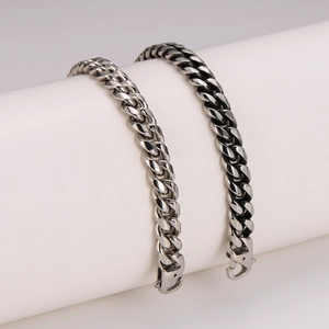Close-up of polished silver and vintage black stainless steel Cuban link bracelets