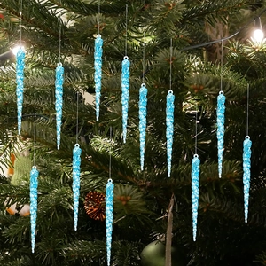 Detailed view of light blue acrylic icicle ornaments hanging on Christmas tree branches