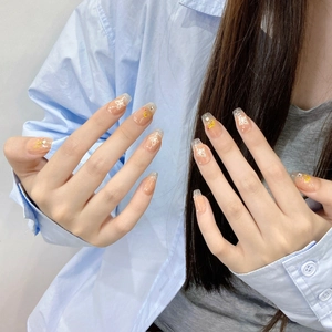Elegant almond press-on nails with nude color blocks, white butterfly, and dried flower