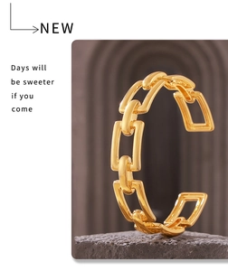 Detail of 18k gold plated hollow chain link open cuff bracelet on a stone stand