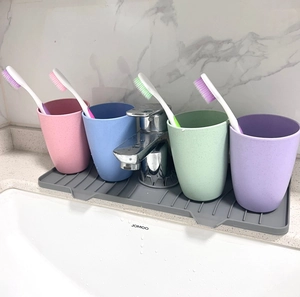 Silicone faucet draining mat with colorful tumblers on a marble bathroom sink