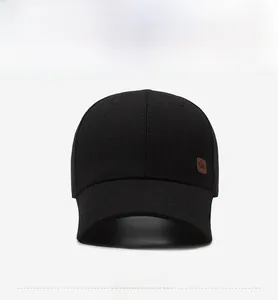 Front view detail of a black baseball cap with a brown KWC leather patch and fabric texture