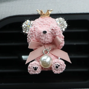 Close-up of pink rhinestone teddy bear air vent aromatherapy clip with a gold crown