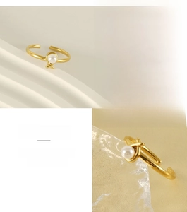 Detail of adjustable gold stainless steel ring with a twisted design and center pearl
