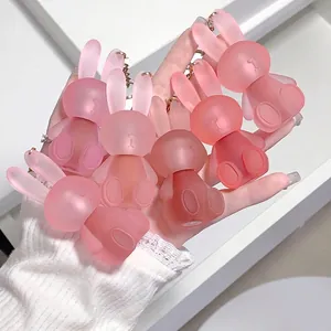 Handheld display of matte pink rabbit keychains with elegant gold chains and cute resin design