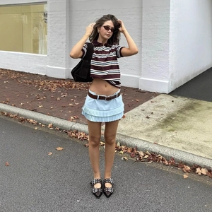 Polo corta retrò a righe con gonna a pieghe blu e cintura marrone look stile di strada