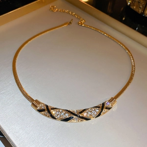 Detailed macro view of vintage curved necklace with black enamel stripes and rhinestones