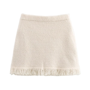 Chic cream knit mini skirt with plush texture and dense fringe trim details