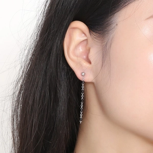 Detail of silver chain earrings with black resin beads and tassel fringe design