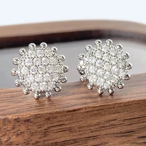 Sparkling silver round stud earrings with pavé cubic zirconia on wooden display stand