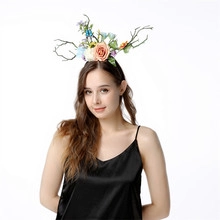 Floral deer antler headband featuring silk pink roses and blue flowers on a model