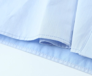 Nahaufnahme des hellblauen Hemdes zeigt feine Twill-Stoffstruktur und präzise Nähte