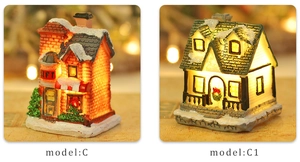 Detail of luminous Christmas resin house models C and C1 with snowy roofs and warm LED light