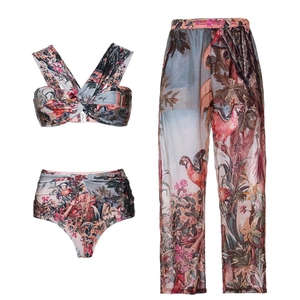 Detailed view of the three-piece tropical parrot print swimsuit and sheer beach pants