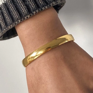 Dettaglio del bracciale minimalista in acciaio inossidabile dorato con finitura a specchio