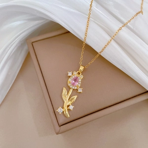 Detailed shot of golden tulip necklace with pink crystal and white pavé gems