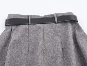 Detailed view of gray herringbone fabric skirt with black belt and white contrast stitching