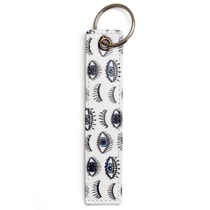 Close-up of faux leather keychain featuring evil eye patterns and silver metal ring