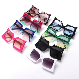 Flat lay of multiple stylish oversized square sunglasses in seven vibrant gradient colors
