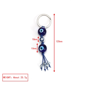 Detail view of evil eye keychain with blue beads and tassel showing dimensions and weight