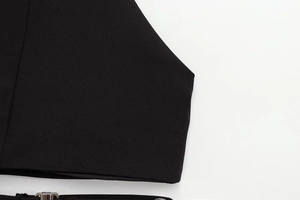 Detail van zwarte stoftextuur met zilveren metalen gesp op een halterneck top