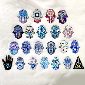 Macro shot of colorful acrylic Hamsa Hand and Evil Eye charms for DIY jewelry making