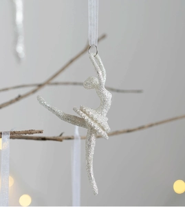 Close-up of sparkling silver ballerina ornament with glitter finish on a Christmas tree