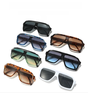 Flat lay of multiple stylish square oversized sunglasses in various colors on white background