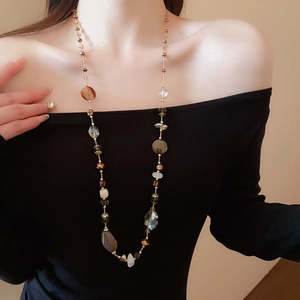 Dettaglio di una collana di perle stile Maillard con giada bianca e agata su una modella