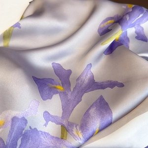 Detailed close-up of smooth lavender silk scarf with purple iris floral pattern print