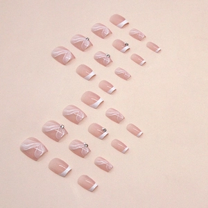 Short square press-on nails in nude pink with French white tips and ribbon bow designs