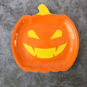 Top view of orange pumpkin face paper plate for Halloween party table decoration
