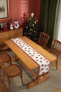 Detail of Christmas table runner featuring red snowflake patterns and festive tassels