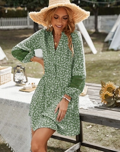 Close-up of green floral dress featuring unique white lace patchwork on long sleeves